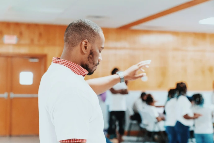 a man standing in a room with people in the background